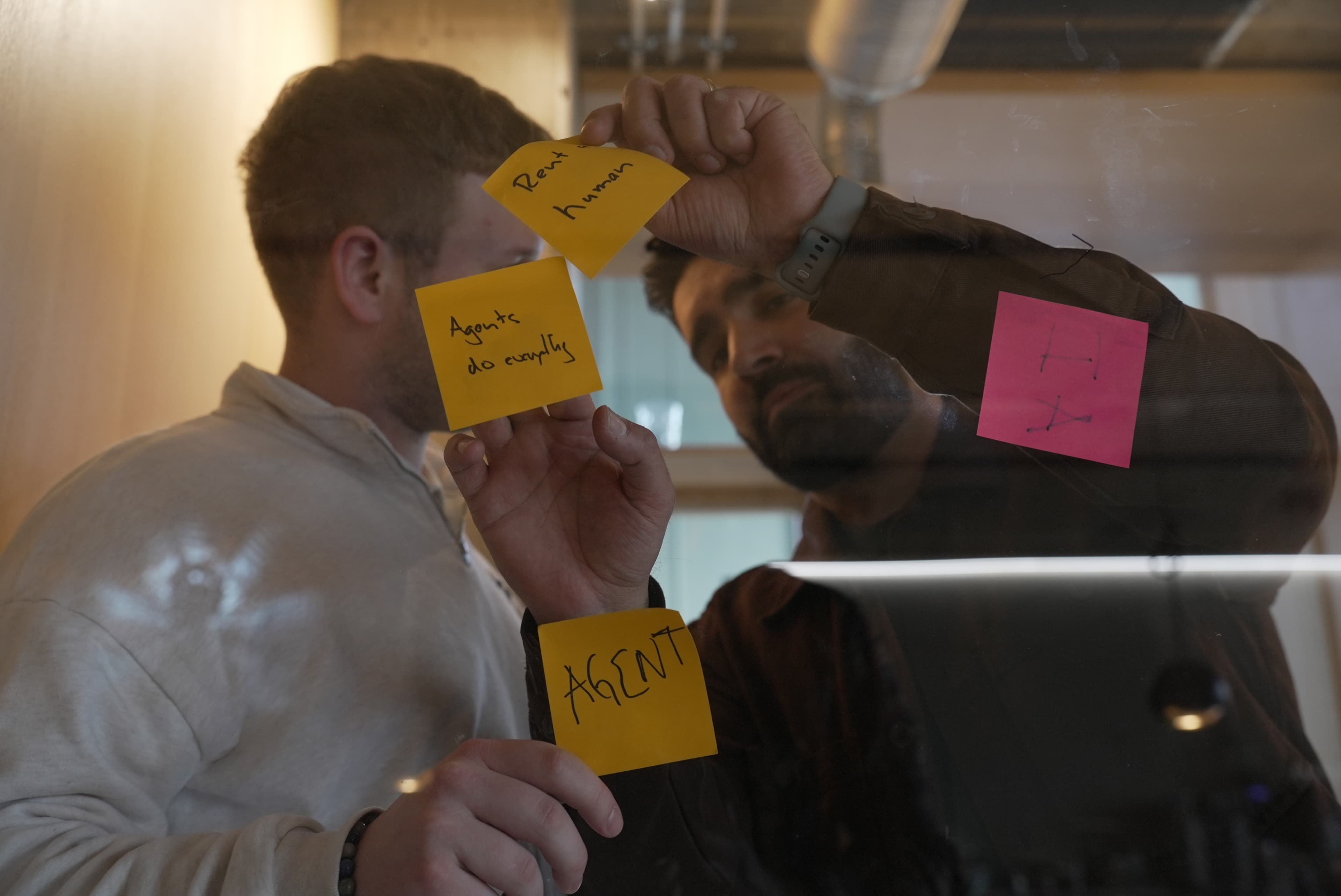 Post-its an einer Glaswand während eines Use-Case-Workshops